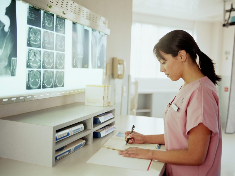 Nurse looking at paperwork in x-ray examination room