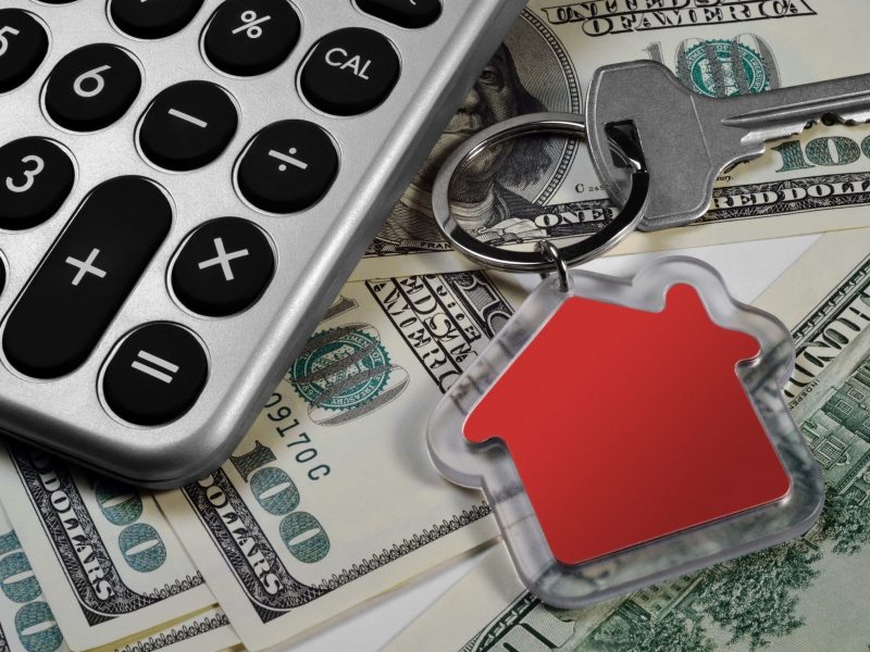 Calculator, US dollars and house key. Close-up