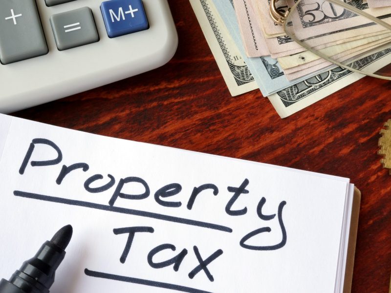Property tax written in a notebook and calculator.