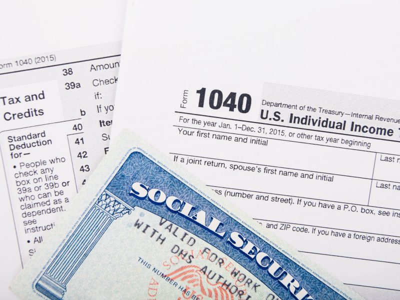 Tax return documents: Form 1040 - U.S. individual income tax return form and Social Security number card.