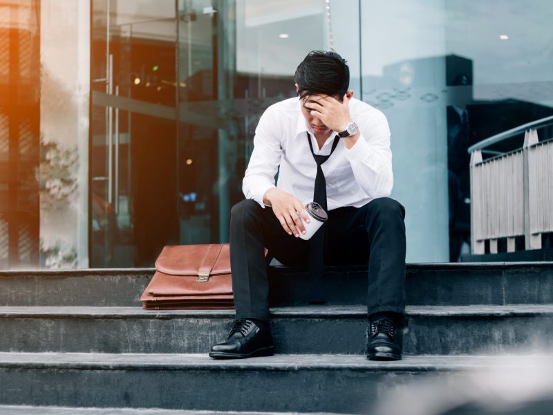 Unemployed Tired or stressed businessman sitting on the walkway after work Stressed businessman concept